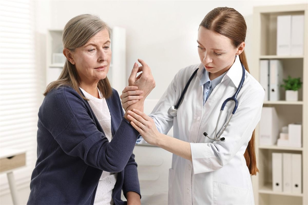 Specialist examining a patient&rsquo;s hand joints